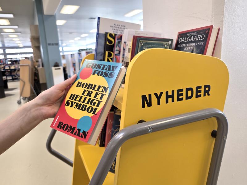 person undersøger en bog ved vognen med nyheder